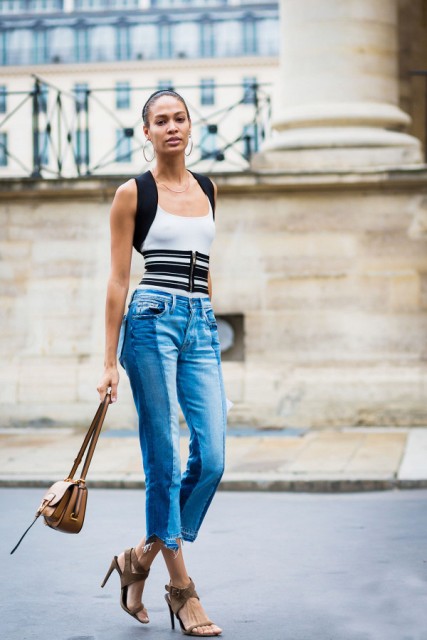 With black and white top, jeans, heels and mini bag