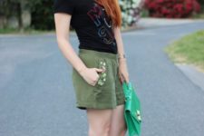 With black t-shirt, olive green shorts and green bag