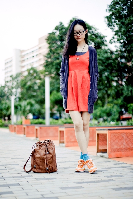 With blue cardigan, orange sneakers and brown backpack