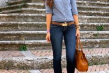 With blue shirt, cuffed jeans and brown bag