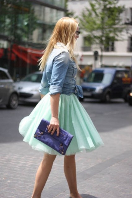 With denim shirt and blue clutch