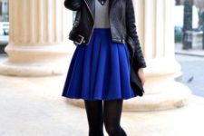 With gray shirt, black leather jacket, black tights and blue shoes