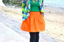 With green shirt, colorful jacket, black tights and platform shoes