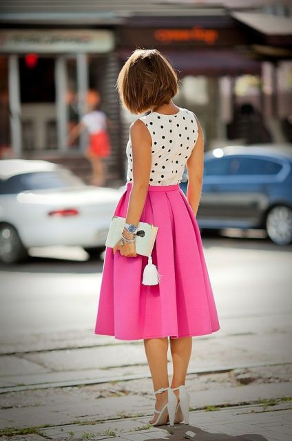 With polka dot top, white heels and white clutch