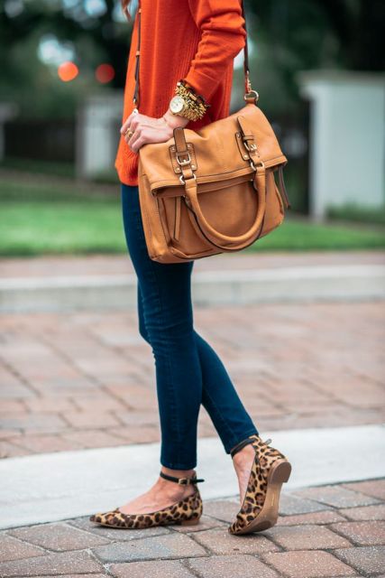 With red shirt, brown leather bag and skinny jeans