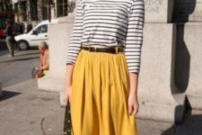 With striped shirt, belt, brown flats and green bag