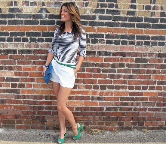 With striped shirt, white shorts, green belt and blue clutch