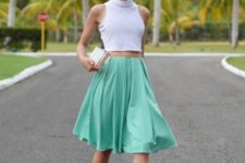 With white crop top, black sandals and clutch