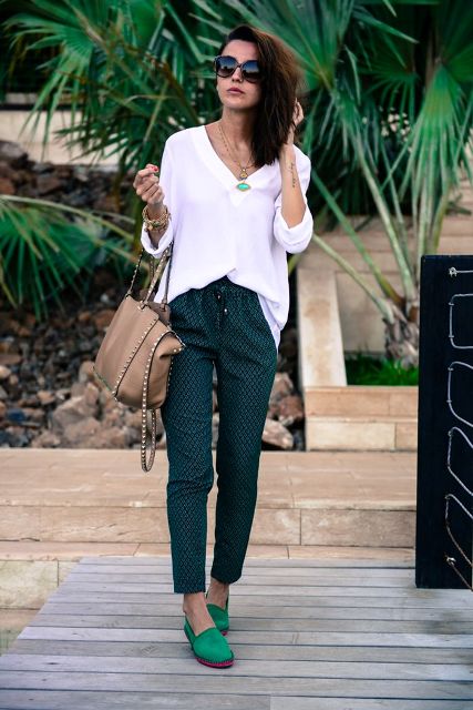 With white oversized shirt, printed pants and beige bag