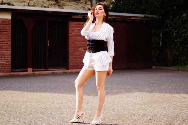 With white shorts, top, striped jacket and heels