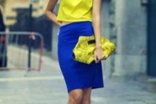 With yellow top, black necklace, yellow shoes and yellow printed clutch