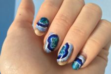 colorful geode-inspired nails in blue, emerald and orange