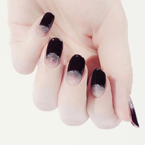 black half moon nails with silver glitter for a glam feel