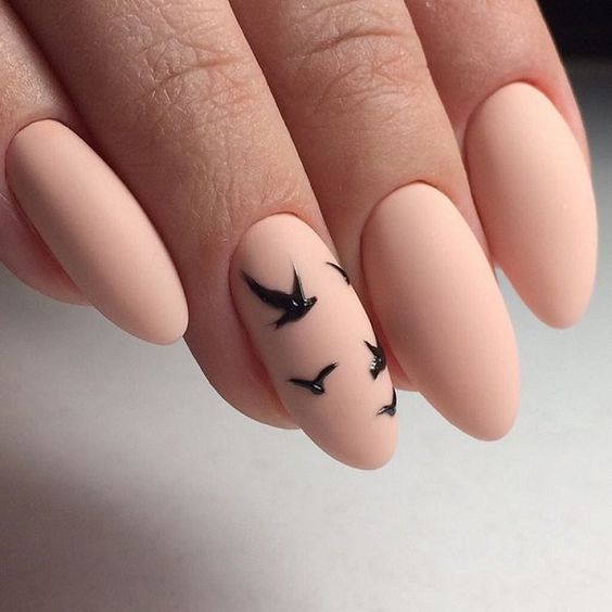 matte pink nails with an accent black bird nail