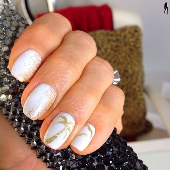 white nails with gold glitter imitating sand and palm trees