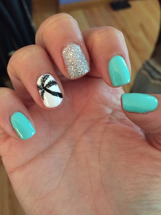 turquoise nails, silver glitter accent and a white nail with a black palm