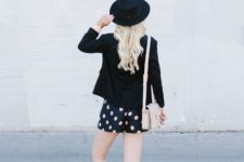 With black jacket, black hat and gray sneakers