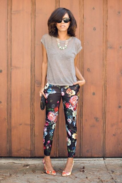 With gray shirt, floral pants and clutch