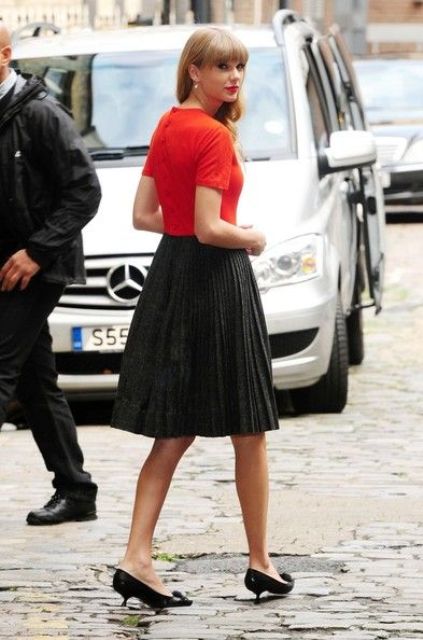 With red shirt and black pleated skirt