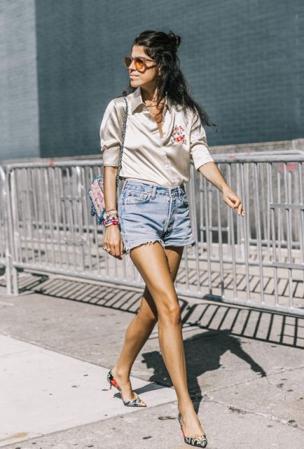 With silk blouse, denim shorts and small printed bag