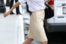 With white shirt, beige knee-length skirt and black bag