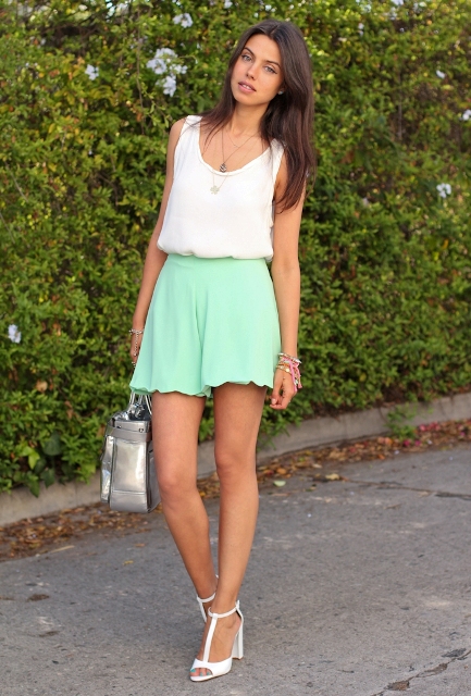 With white top, white sandals and metallic bag