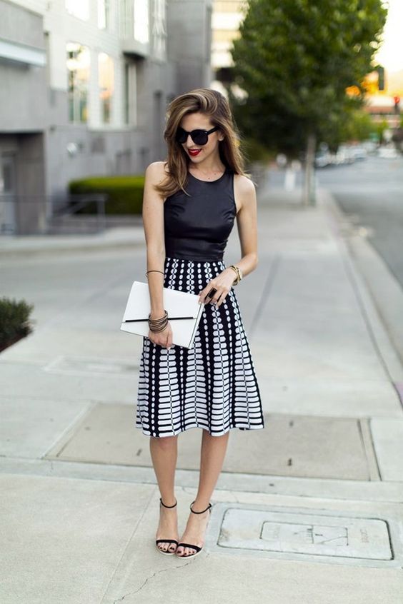 a black halter top, a black and white printed midi skirt and black suede sandals