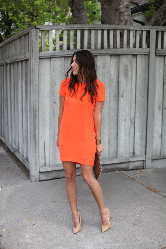 a bold orange mini dress with short sleeves and nude heels