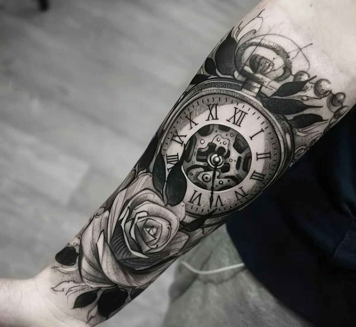 Big rose and clock tattoo on the arm