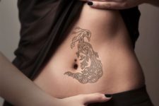 Graceful black-contour tattoo on the belly
