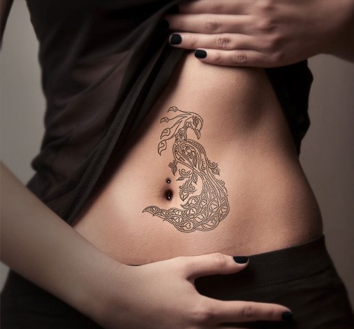 Graceful black-contour tattoo on the belly