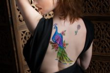 Peacock with flowers tattoo on the back