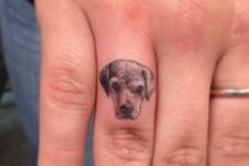 Tiny dog tattoo on the finger