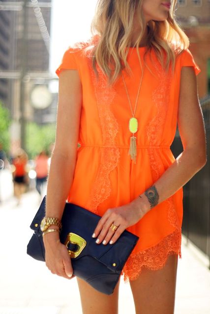 With golden necklace and navy blue clutch