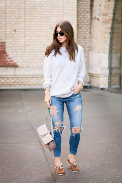 With loose sweatshirt, distressed jeans and small bag