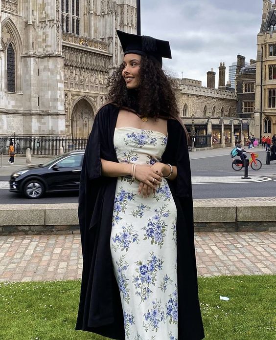 a floral strapless midi dress, a black robe and a hat are a cute and lovely outfit for graduation