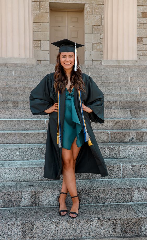 a green satin mini dress, a black robe, black shoes and a hat are a cool and sexy outfit for graduation