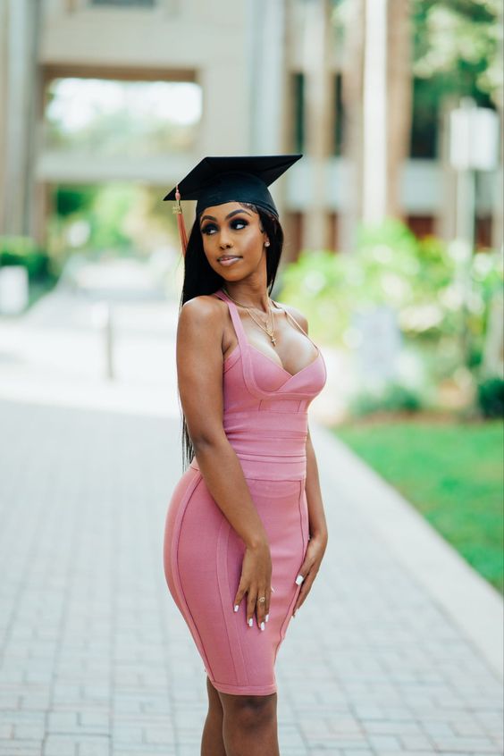 a pink bodycon strappy knee dress with a depe neckline and a black hat are all you need to look sexy at graduation