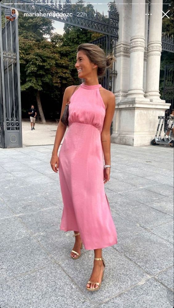a pink satin midi dress with a halter neck, gold shoes and a small bag are a lovely and chic outfit for graduation
