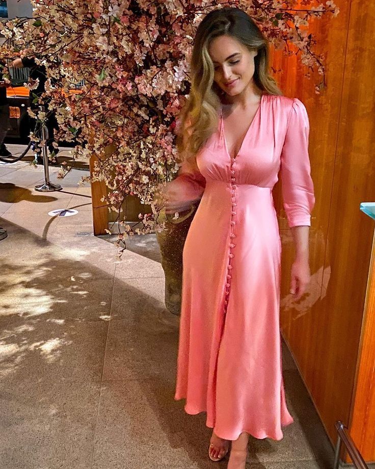 a pink satin midi dress with a row of buttons, long sleeves and a deep neckline plus clear shoes for a tender and lovely look