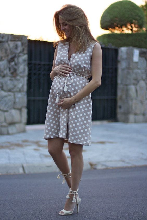 a neutral polka dot sleeveless dress with a v neckline and lace up creamy shoes