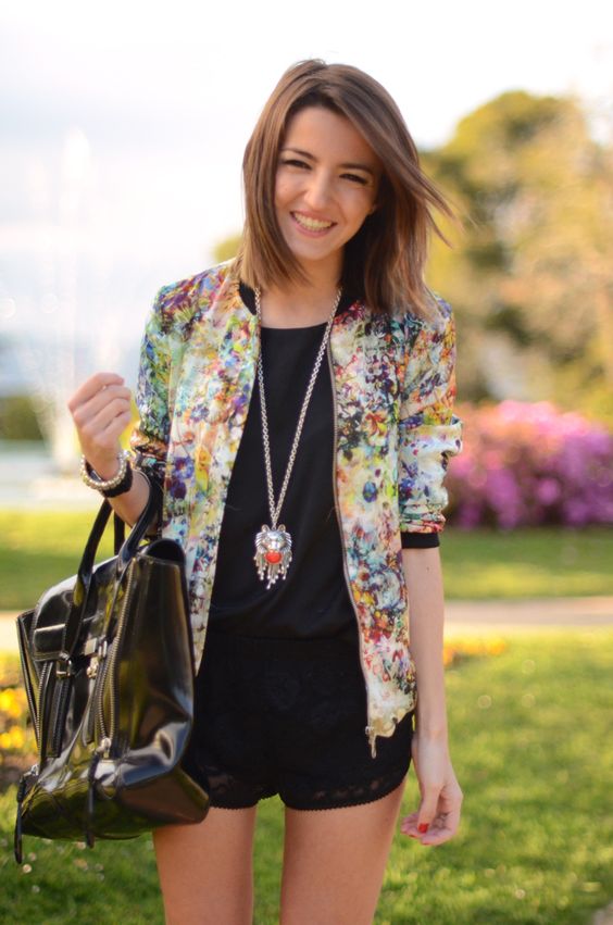 black lace mini shorts, a black top and a bold floral blazer and a large tote