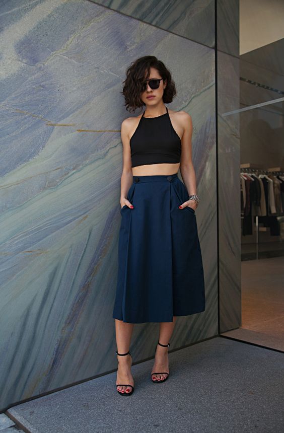 a black halter neckline top, a navy midi skirts with pockets and black heels