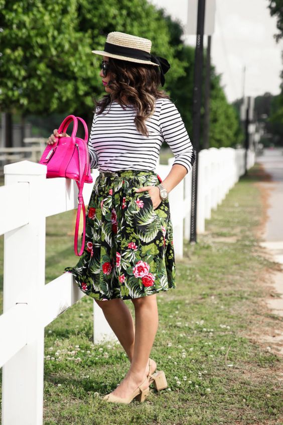 a tropical print knee skirt, a striped black and white long sleeve, neutral heels and a hot pink bag