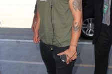 07 black jeans, black leather boots and an olive green t-shirt and a cap