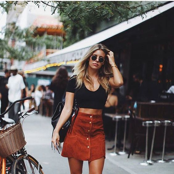a red suede mini skirt with a button row and a black crop top for a casual summer look