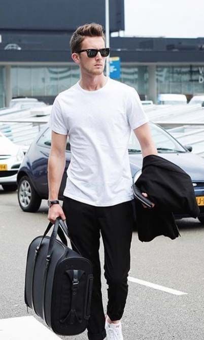 black pants, a white tee, white sneakers and a black bag to travel with style