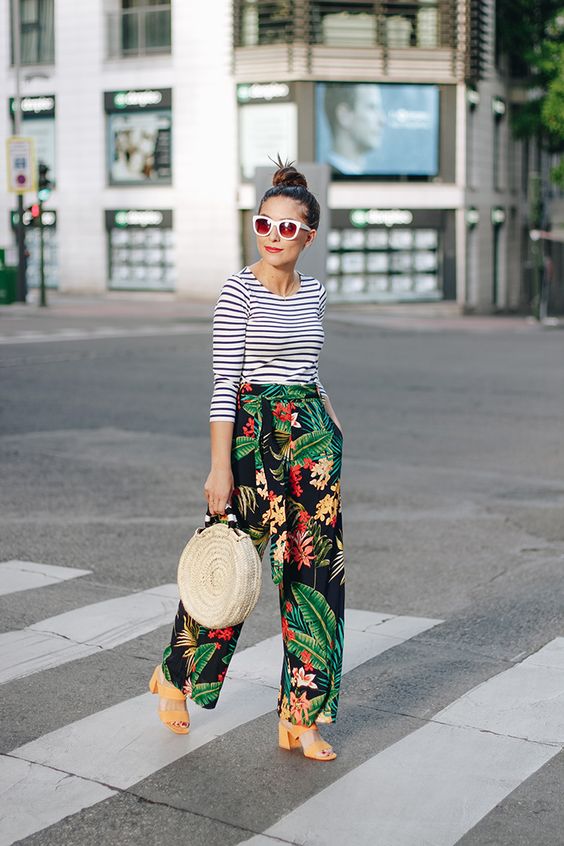 a striped blue and white long-sleeve and tropical print pants, nude heels and a straw round bag