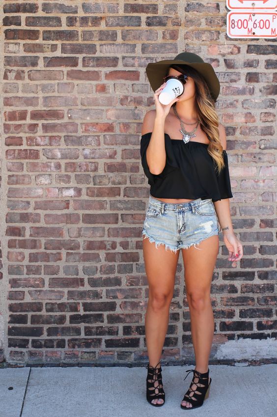 a black off the shoulder crop top, distressed denim shorts and black suede lace up shoes