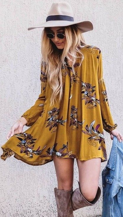 a mustard mini dress with long sleeves and a floral print with suede boots and a hat